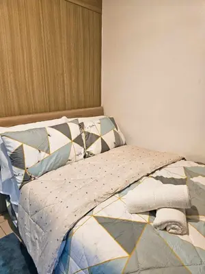 a bed with pillows on it in a bedroom at Sweet Villa SMDC Breeze Residences Pasay in Manila