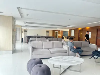 a man sitting on a couch in a living room at Sunset heights SMDC Breeze Residences Pasay in Manila