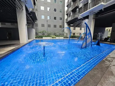 a large blue pool with a water slide in a building at S Residences Tower 1 - near MOA & Ayala Malls Manila Bay in Manila