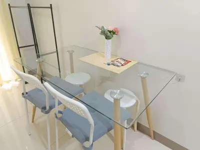 a glass table with chairs and a vase with flowers on it at S Residences Tower 1 - near MOA & Ayala Malls Manila Bay in Manila