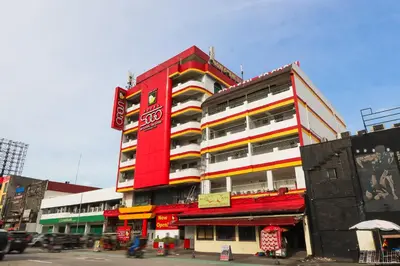 a tall red building with colorful balconies on a city street at Hotel Sogo Baclaran in Manila