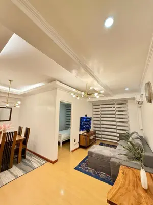 a living room with a couch and a table at Avant BGC 2 Bedroom in Manila