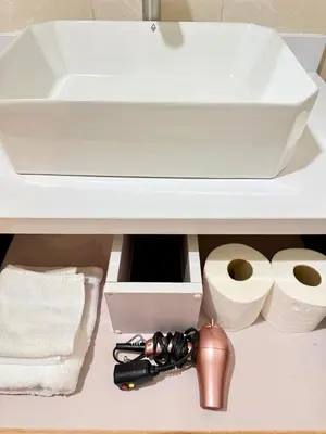 a bathroom sink with toilet paper and rolls of toilet paper at Avant BGC 2 Bedroom in Manila
