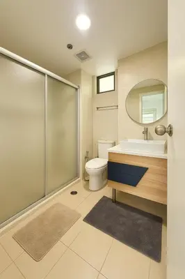 a bathroom with a toilet sink and a mirror at Avant BGC 2 Bedroom in Manila