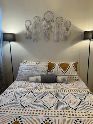 a bedroom with a bed with pillows and masks on the wall at Osaka Theme LRT Gilmore Robinsons Magnolia Free Netflix Internet Pool in Manila