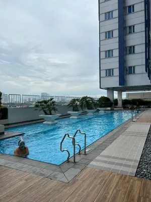 a person in a swimming pool on a building at Osaka Theme LRT Gilmore Robinsons Magnolia Free Netflix Internet Pool in Manila