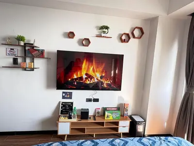 a living room with a fireplace on the wall at Sy bay Suites Okada NAIA T3 T1 Airport MOA COD DFA MSV1506H in Manila