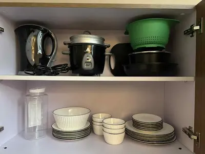 a cupboard with dishes and a pot and plates at Casa Forma in Manila