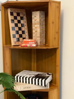 a wooden book shelf with a chess board on it at Casa Forma in Manila