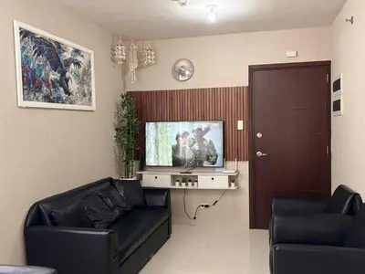 a living room with a couch and a flat screen tv at Serene Suites Condo unit in Bacoor