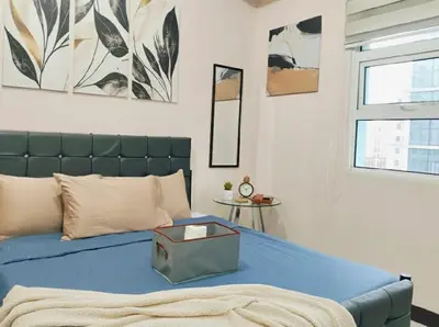 a bedroom with a bed with a blue bedspread at #Affordable Condotel Newport Boulevard in Manila