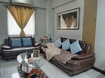 a living room with a leather couch and a glass table at Super Cozy Apartment-Newport Boulevard in Manila