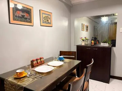 a dining room with a table and some chairs at Super Cozy Apartment-Newport Boulevard in Manila