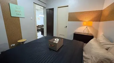 a bedroom with a bed and a table with a candle on it at Super Cozy Apartment-Newport Boulevard in Manila