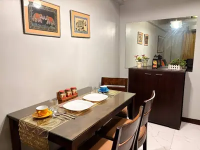 a dining room with a table and some chairs at Super Cozy Apartment-Newport Boulevard in Manila