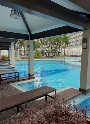 a large swimming pool with blue water at Shell and Shorline Bliss Manila Staycation in Manila