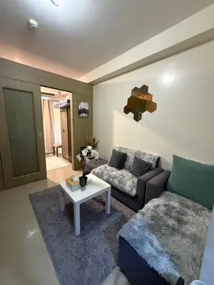 a living room with a couch and a table at Shell and Shorline Bliss Manila Staycation in Manila