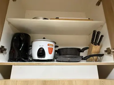 a slow cooker sitting on top of a kitchen shelf at Shell and Shorline Bliss Manila Staycation in Manila