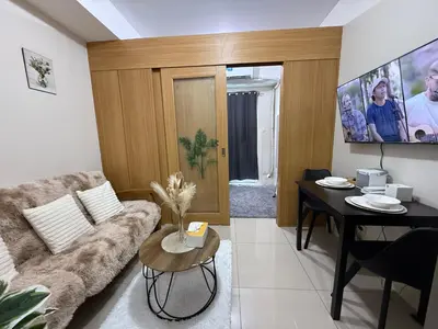 a living room with a couch and a table at Shell and Shorline Bliss Manila Staycation in Manila