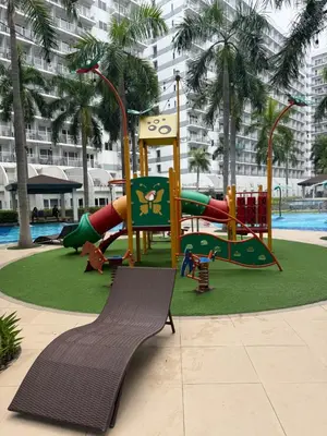 a playground in a resort with a slide and a bench at Shell and Shorline Bliss Manila Staycation in Manila
