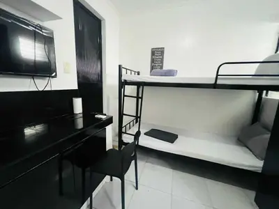 a room with two bunk beds and a desk at T&A Building in Manila