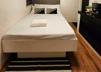 a bed in a bedroom with a white mattress at T&A Building in Manila