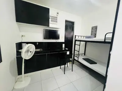 a small room with a fan and a microwave at T&A Building in Manila