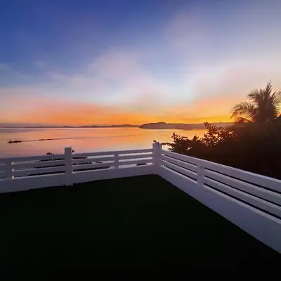a white fence with a sunset in the background at OYO 1175 Casa Ana in Manila