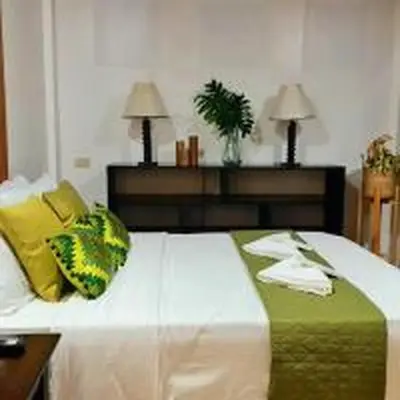 a bedroom with a bed with yellow and green pillows at OYO 1175 Casa Ana in Manila