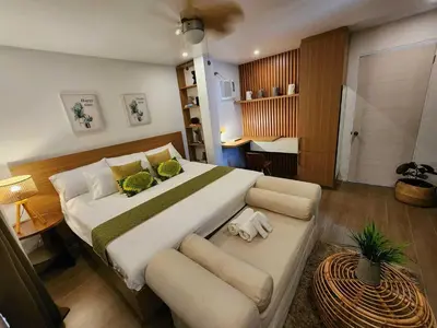 a bedroom with a large bed and a couch at OYO 1175 Casa Ana in Manila