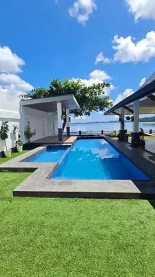 a swimming pool with a gazebo and the ocean at OYO 1175 Casa Ana in Manila