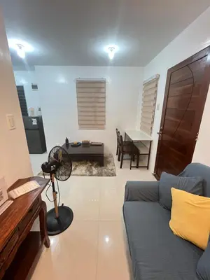 a living room with a blue couch and a table at Motorists Transient House in Carmona