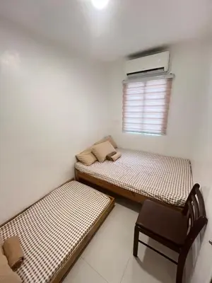 a small room with two beds and a chair at Motorists Transient House in Carmona