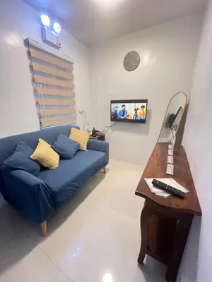 a living room with a blue couch and a table at Motorists Transient House in Carmona