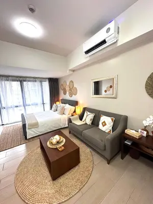 a living room with a bed and a couch at Tahanan Studio at Salcedo Skysuites in Manila