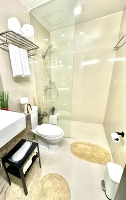 a bathroom with a shower and a toilet and a sink at Tahanan Studio at Salcedo Skysuites in Manila