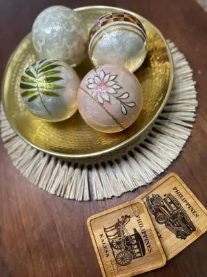 a gold plate with three stones on a table at Tahanan Studio at Salcedo Skysuites in Manila