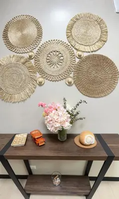 a table with a vase of flowers and plates on a wall at Tahanan Studio at Salcedo Skysuites in Manila