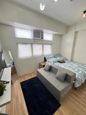 a bedroom with a bed and a couch at Holly's Place by Motorists Transient House in Biñan