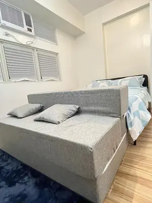 a bed with two pillows on it in a bedroom at Holly's Place by Motorists Transient House in Biñan