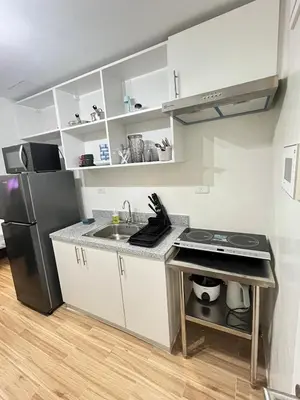 a small kitchen with a sink and a refrigerator at Holly's Place by Motorists Transient House in Biñan