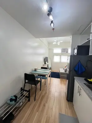 a kitchen with a table and chairs in a room at Holly's Place by Motorists Transient House in Biñan