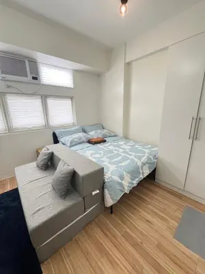 a bedroom with a bed and a couch in it at Holly's Place by Motorists Transient House in Biñan