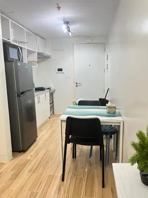 a kitchen with a table and a refrigerator at Holly's Place by Motorists Transient House in Biñan