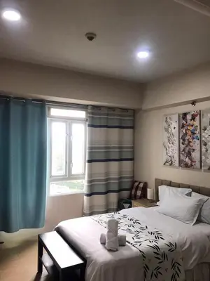 a bedroom with a large bed and a window at Condo Unit Near NAIA T3 in Manila