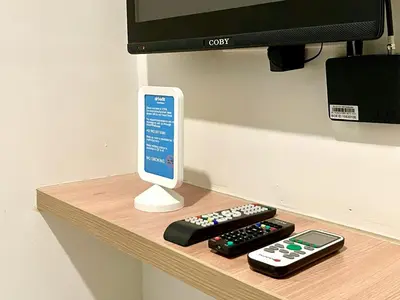 a shelf with two remote controls and a tv at airobedz ZOBEL ROXAS- A Value Hotel in Manila