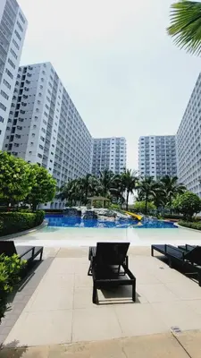 a park with benches in front of tall buildings at Condo MOA Complex Pasay - Shore 1 Tower D Residence - Home away from Home in Manila