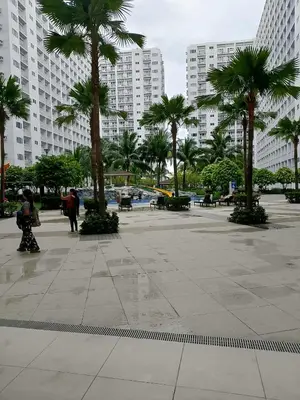 a courtyard with palm trees in a city with tall buildings at Condo MOA Complex Pasay - Shore 1 Tower D Residence - Home away from Home in Manila
