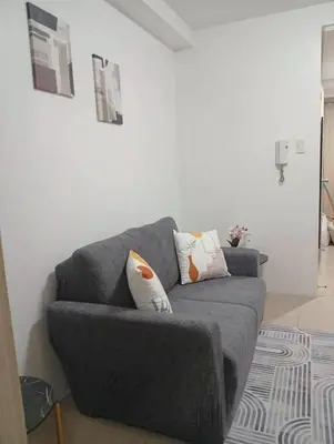 a living room with a gray couch with pillows at Condo MOA Complex Pasay - Shore 1 Tower D Residence - Home away from Home in Manila