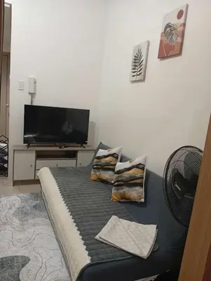 a living room with a couch and a flat screen tv at Condo MOA Complex Pasay - Shore 1 Tower C2 Residence - Home away from Home in Manila